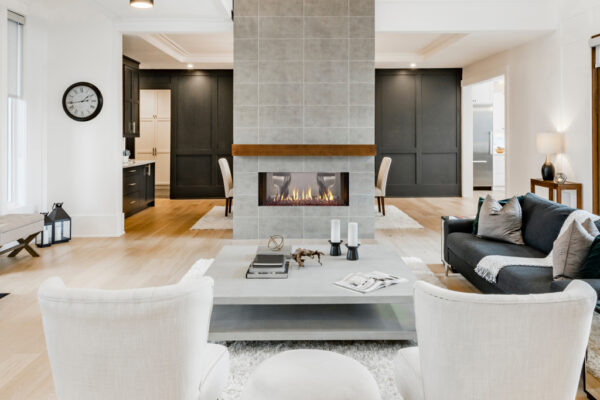 Large open concept great room with fireplace and wooden beams